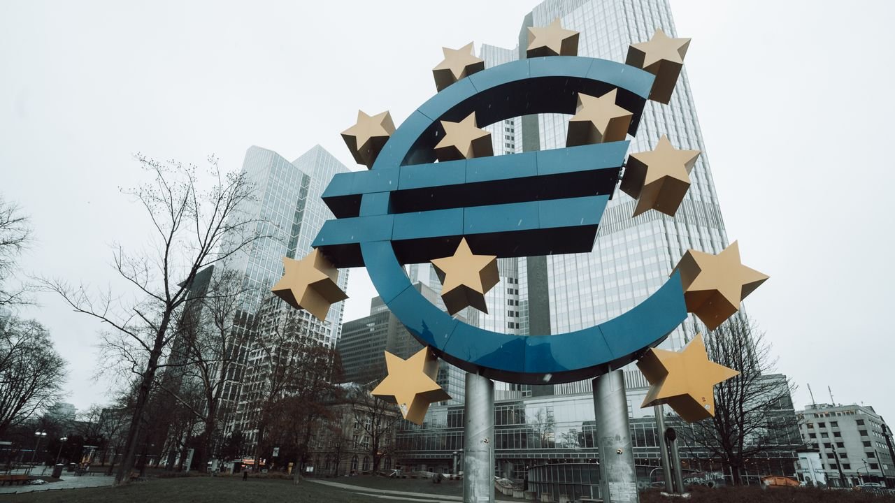 Iconic Euro sculpture in front of skyscrapers in Frankfurt during a winter day.