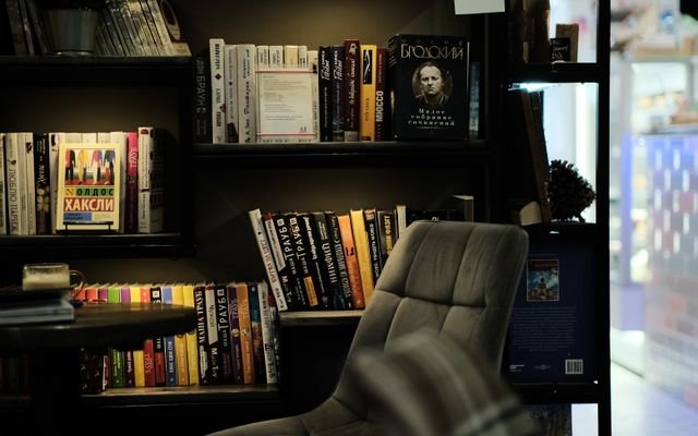 Modern office spot with bookshelf featuring a variety of books and stylish armchair.