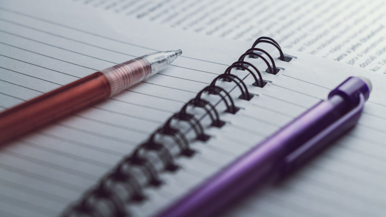 A detailed view of spiral notebooks and pens, perfect for office or school settings.