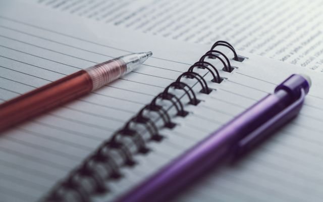 A detailed view of spiral notebooks and pens, perfect for office or school settings.