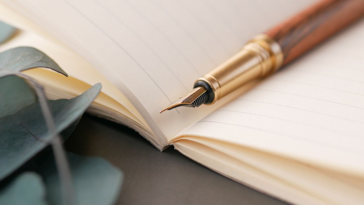 A closeup of a luxurious fountain pen resting on a lined notebook, perfect for writing enthusiasts.