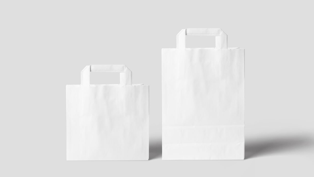 Minimalist white paper bags on a neutral background perfect for branding and design projects.