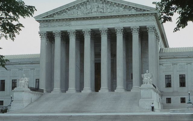 Front view of the iconic Supreme Court building with classical columns and majestic architecture.