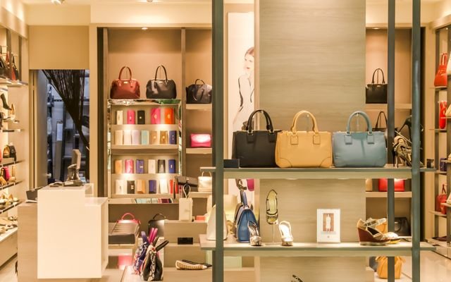 Chic boutique with a variety of handbags and shoes elegantly displayed on shelves.