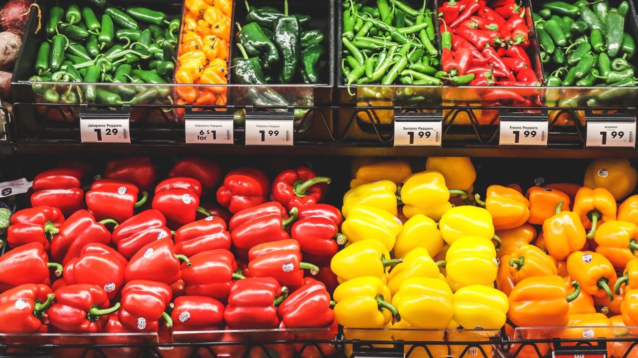 Vibrant variety of peppers on supermarket shelves. Perfect for healthy food and grocery themes.