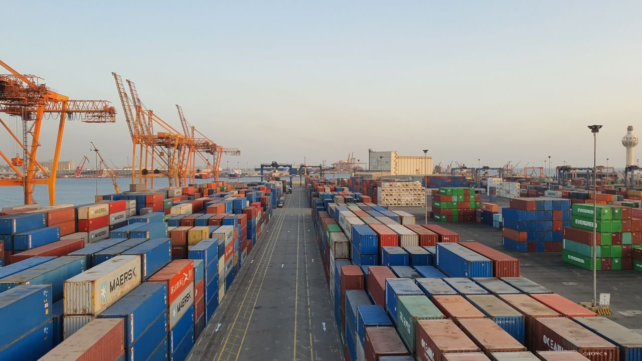 A bustling port scene with colorful cargo containers at sunrise. Ideal for logistics concepts.