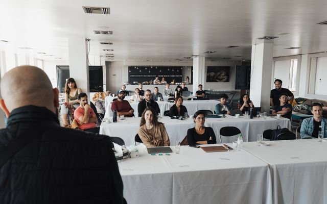 A diverse group of business professionals attending a presentation in a modern conference room.