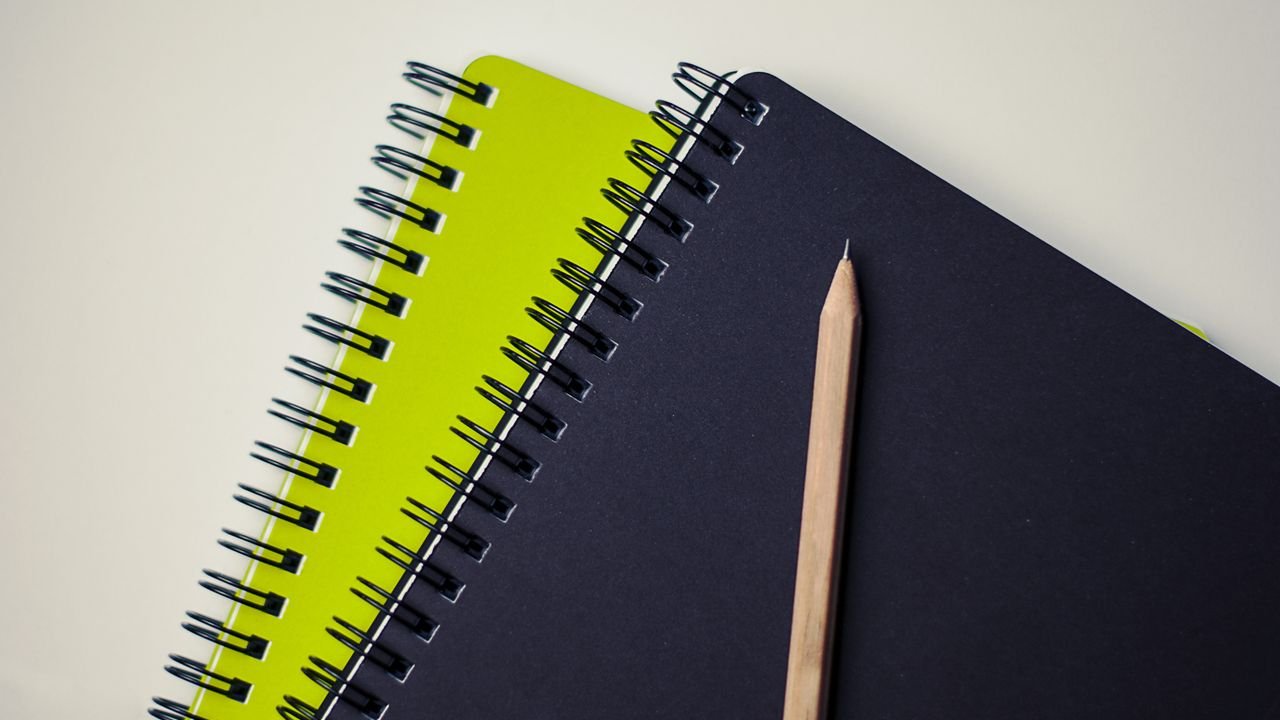 Close-up of spiral-bound notebooks with a pencil, perfect for creative projects.