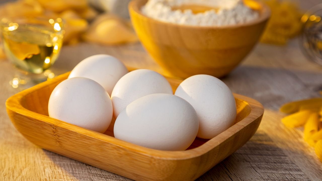 A warm, rustic photo featuring eggs and flour in a wooden setting, ideal for baking themes.
