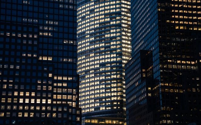 Skyscrapers with glowing windows create a vibrant nighttime cityscape.