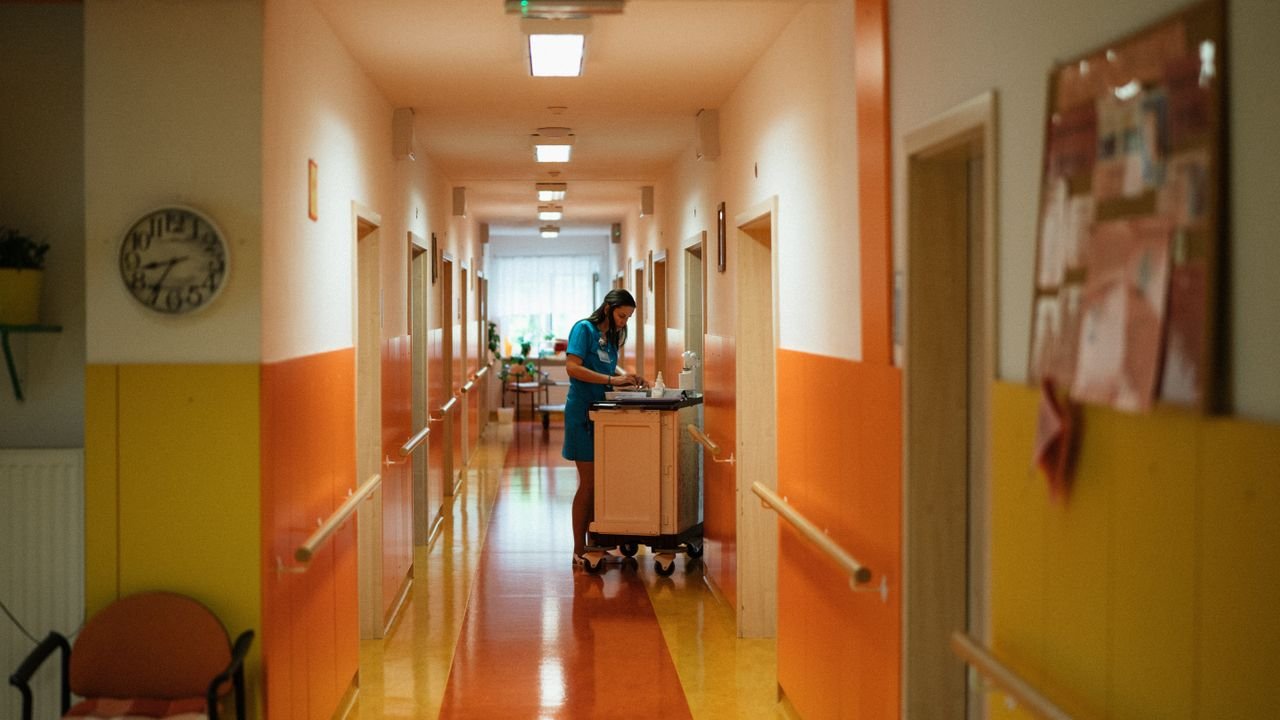 A nurse attending to duties in a colorful hospital corridor in Karviná, Czech Republic.