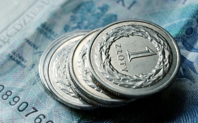 Close-up of Polish zloty coins stacked on a banknote. Financial concept.