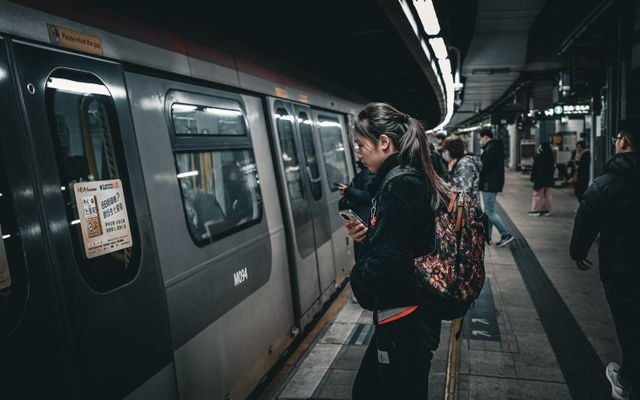 Commuters boarding a subway train at an underground station, showcasing public transit dynamics.