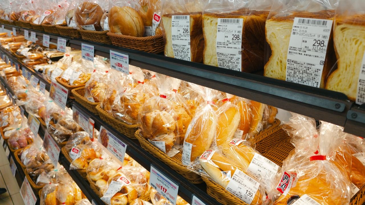 A diverse selection of prepackaged bread in a grocery store aisle, perfect for food-related projects.