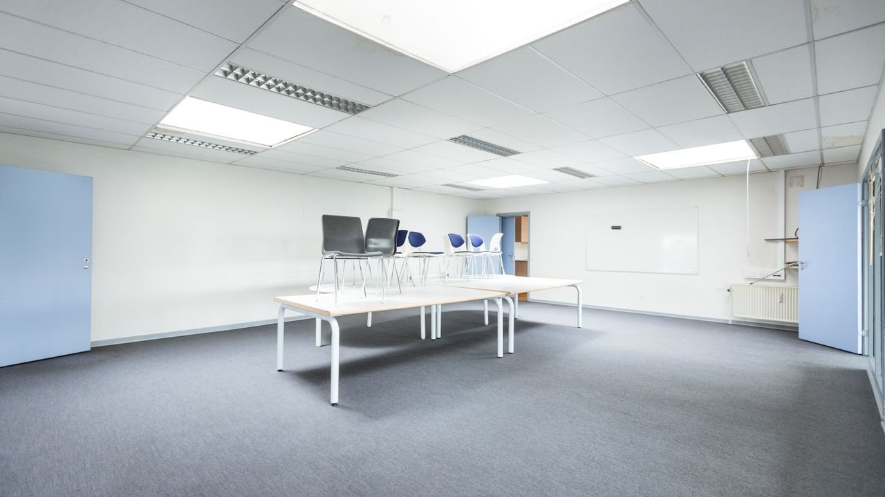 Spacious minimalist office with tables and chairs arranged creatively.