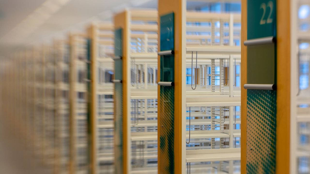 A modern library with rows of empty numbered bookshelves, offering a blurred perspective.