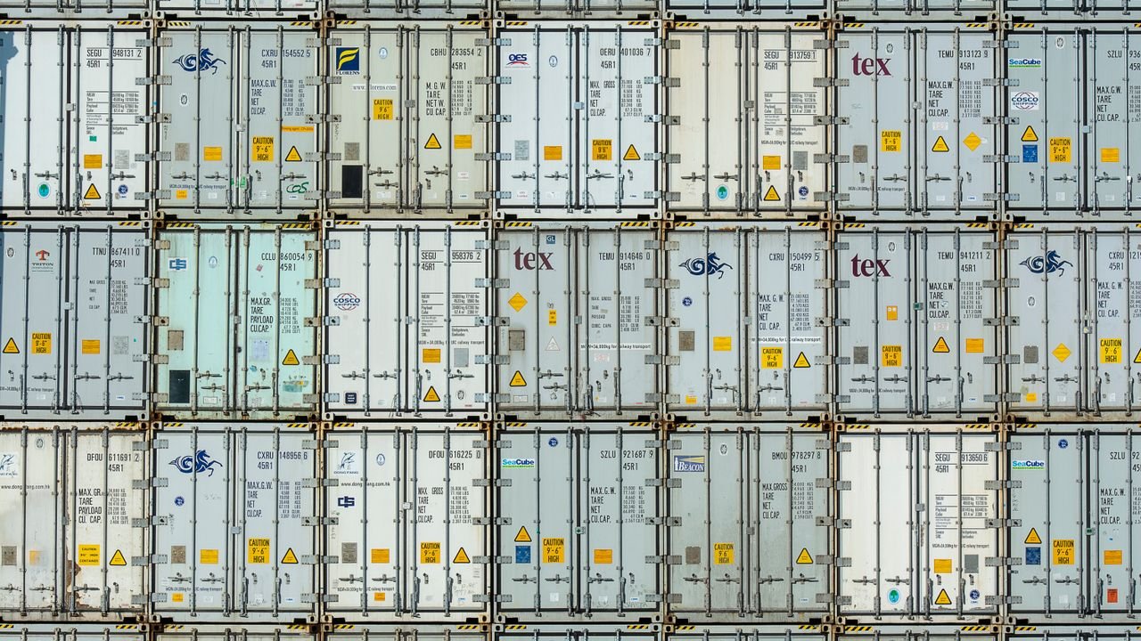 A patterned array of industrial shipping containers stacked in a storage terminal.
