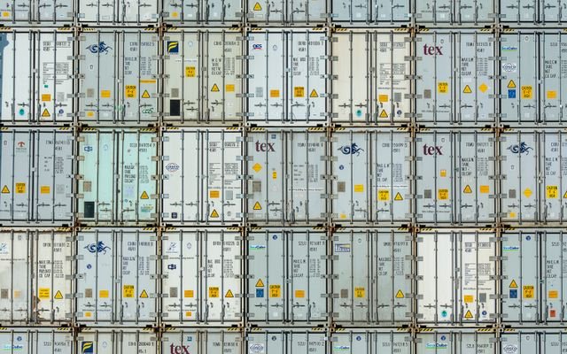 A patterned array of industrial shipping containers stacked in a storage terminal.
