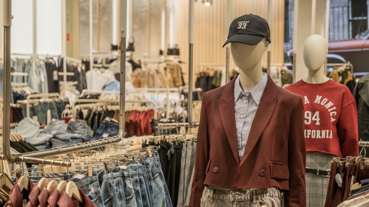 Fashion mannequins in stylish clothing display in a contemporary retail setting.