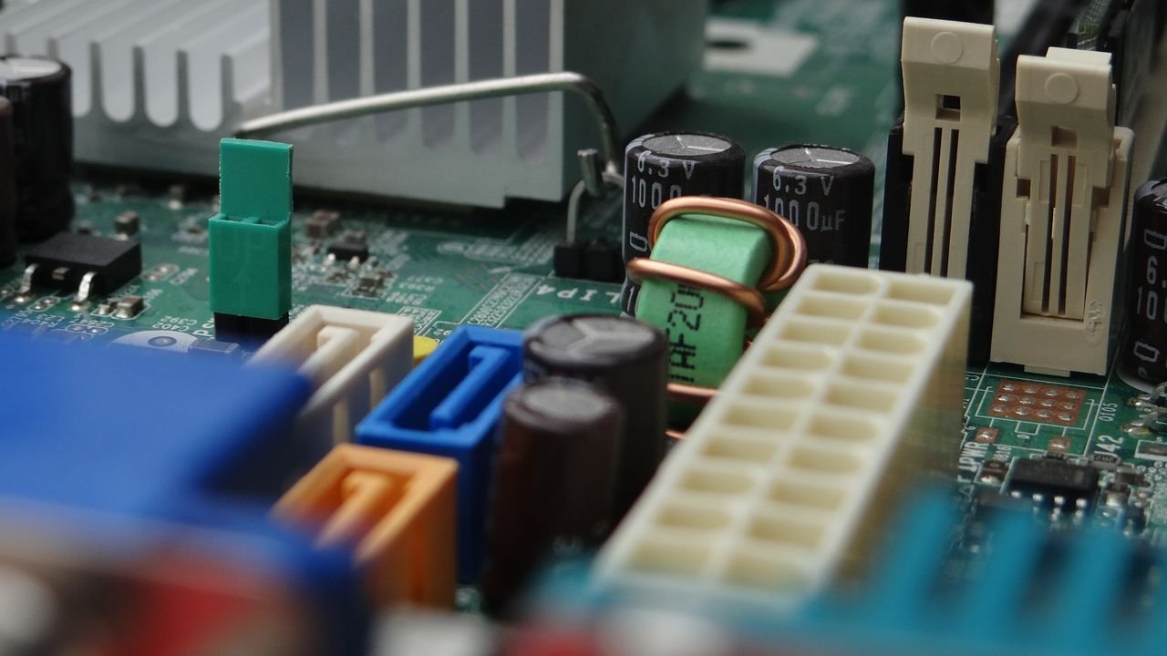 Detailed view of electronic components on a computer motherboard focusing on connectors and capacitors.