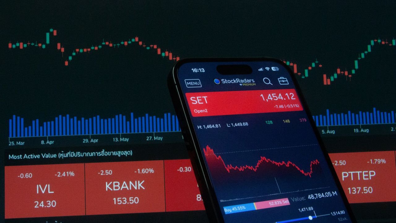 Mobile app showing stock market data with charts on screen.