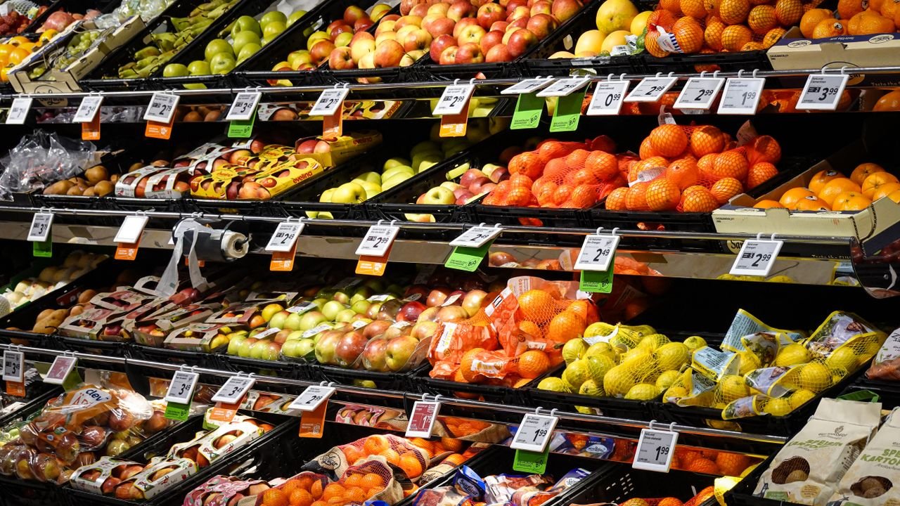 Colorful assortment of fresh fruits neatly arranged on supermarket shelves, ideal for healthy eating themes.