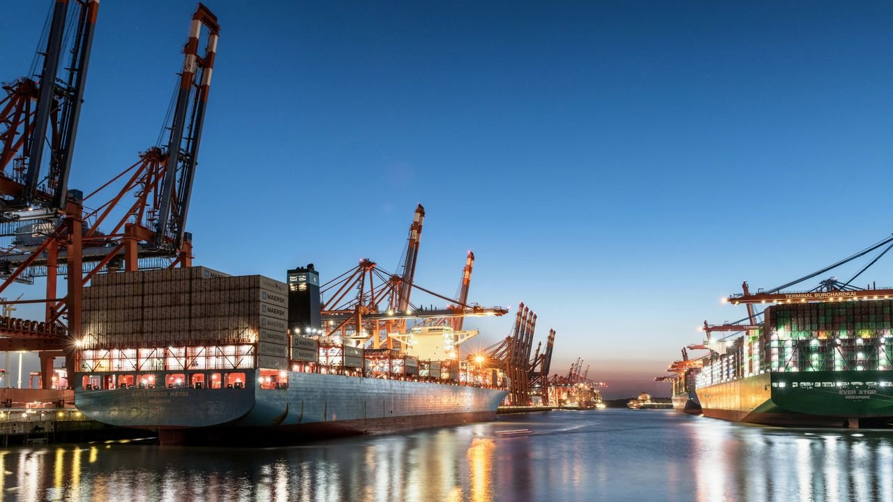 Scenic view of container ships docked at Hamburg port during early evening, highlighting global trade.