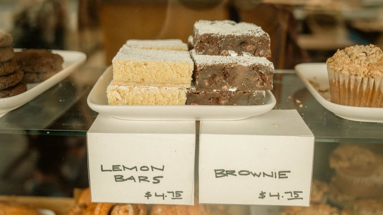 Delicious display of lemon bars and brownies in a bakery with price tags.