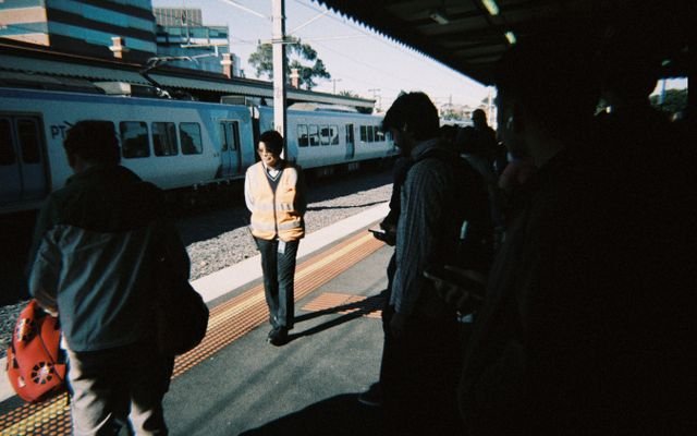 Commuters waiting for a metro train at a station in Melbourne, capturing morning bustle.