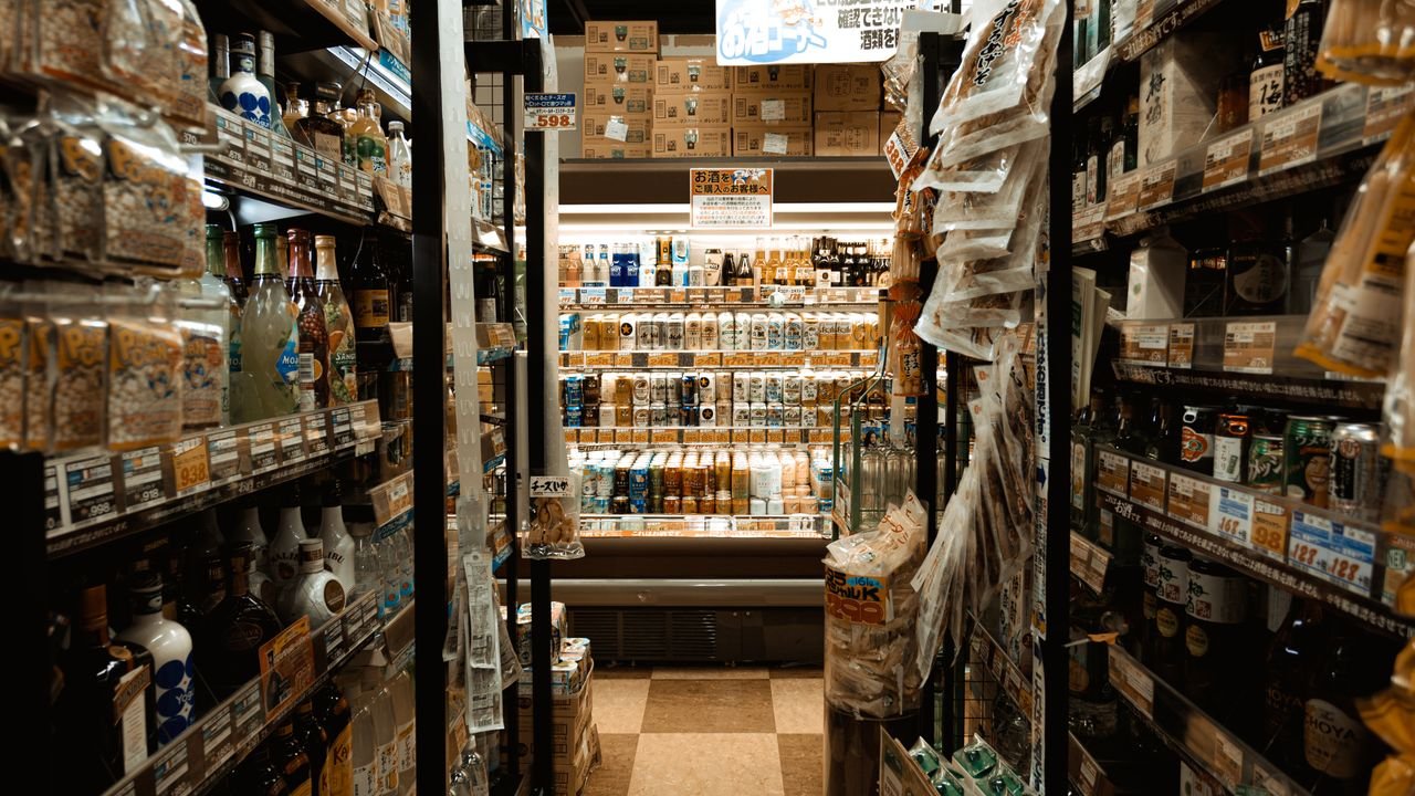 Explore a bustling Tokyo convenience store aisle packed with diverse products and merchandise.