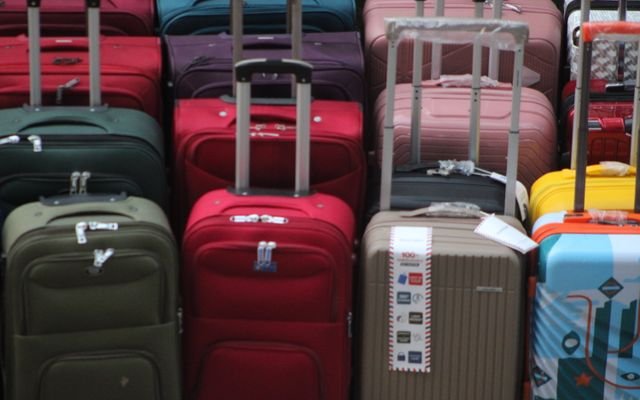 A vibrant collection of various suitcases stacked in preparation for travel.