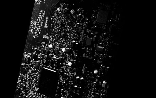 Detailed black and white close-up of a circuit board showcasing modern technology.