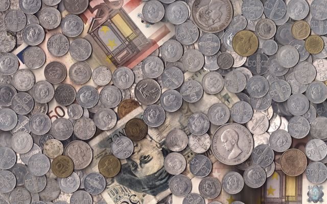 A collection of various European currency coins and notes in a scattered arrangement.