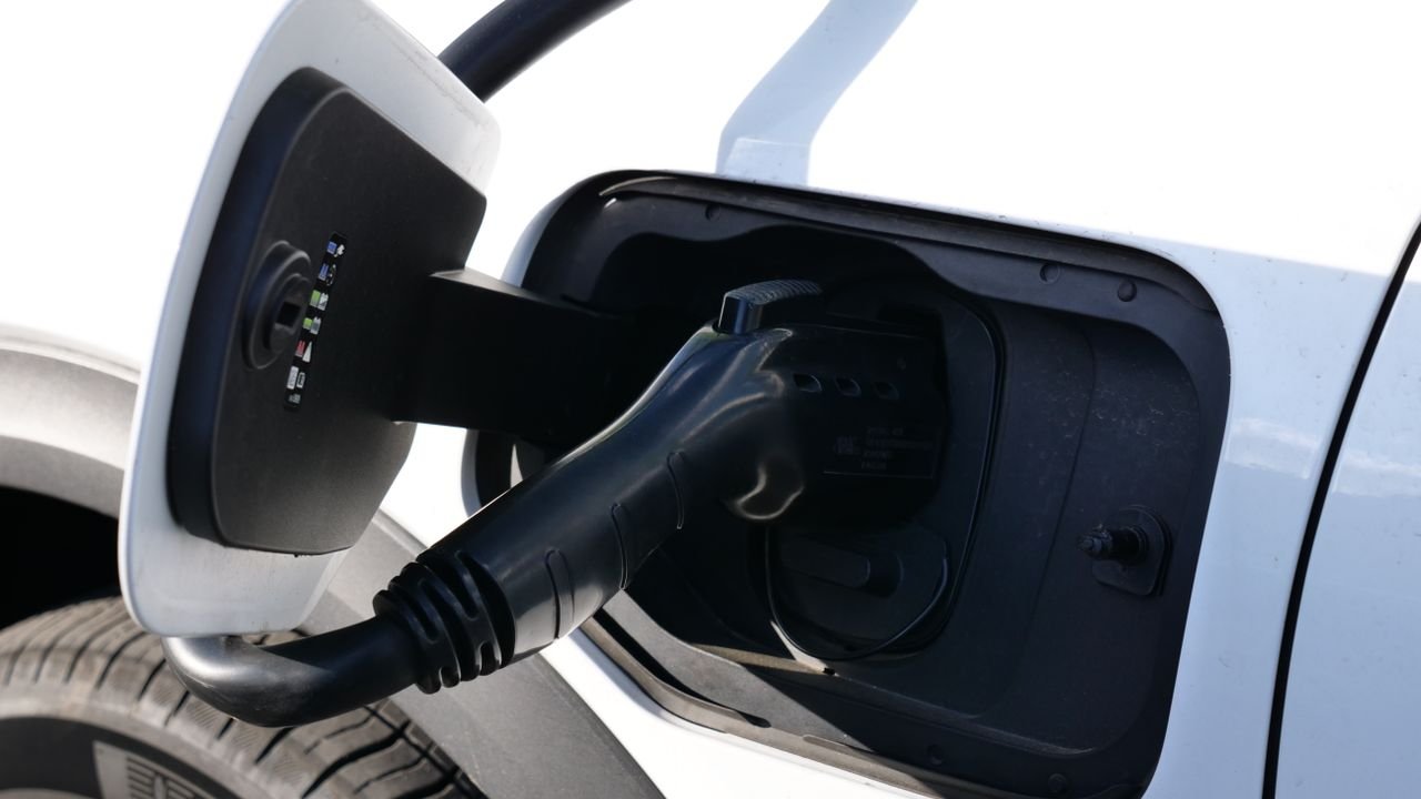 Close-up view of an electric vehicle charging with a focus on the connector and charging port.