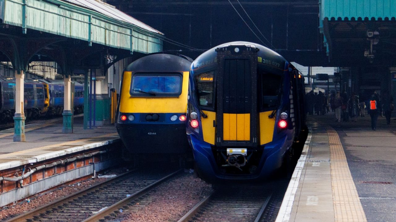 Two trains at Edinburgh Waverley Station showcase Scottish rail travel.