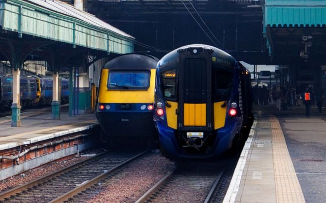 Two trains at Edinburgh Waverley Station showcase Scottish rail travel.