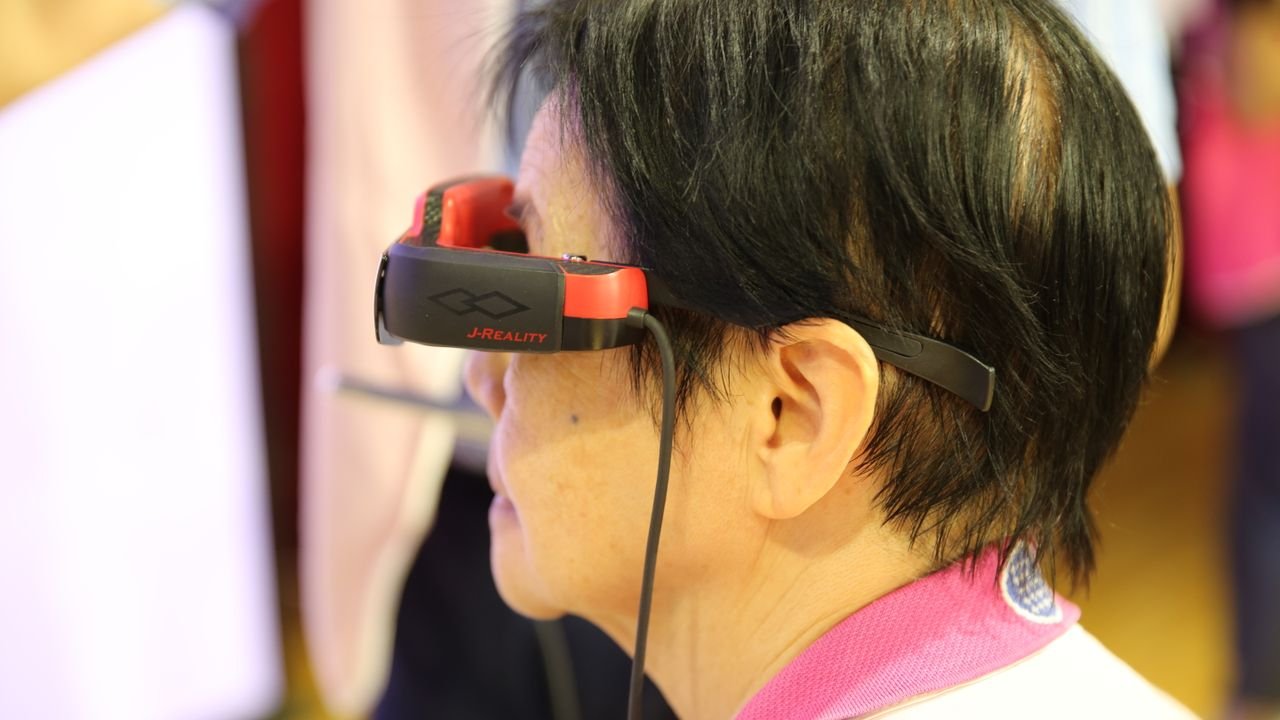 Adult engaged with virtual reality headset indoors at a technology event.