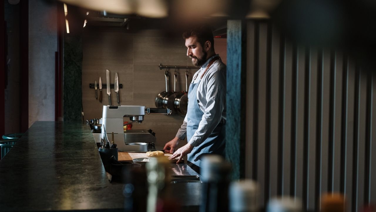 A skilled chef preparing ingredients in an industrial kitchen setting.