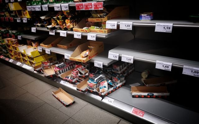 High angle of empty and full shelves in supermarket with price tags and cardboard boxes