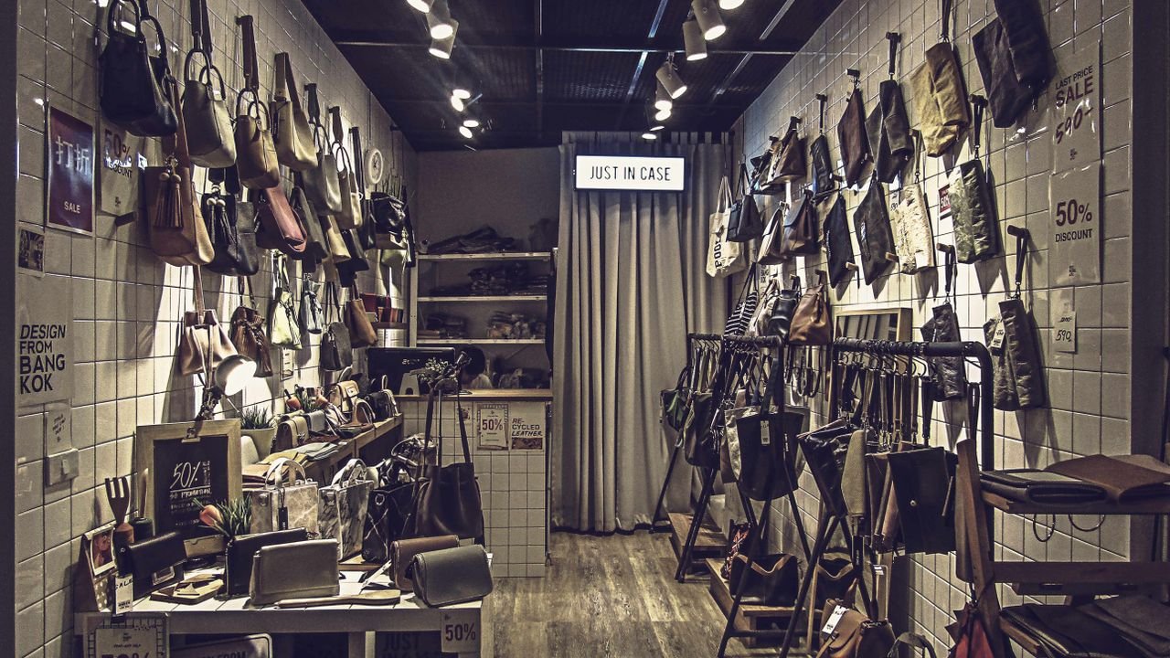 Stylish boutique store interior featuring an elegant collection of luxury bags displayed on tiled walls.