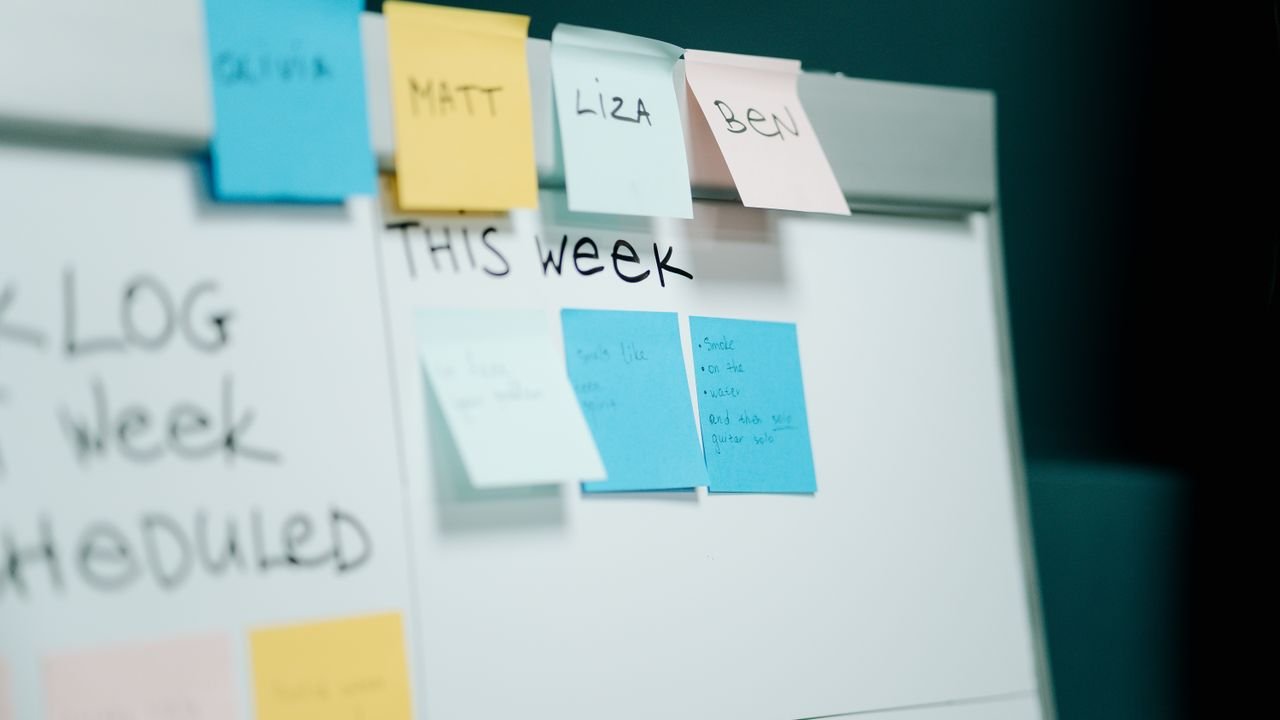 Close-up of a whiteboard with colorful sticky notes for task organization and planning.