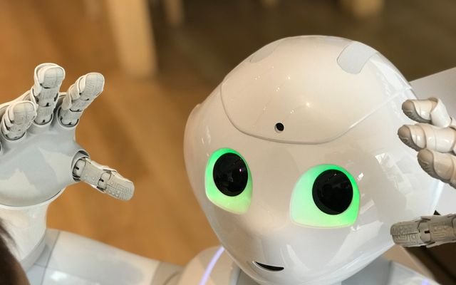 A futuristic humanoid robot with glowing green eyes in a modern setting.