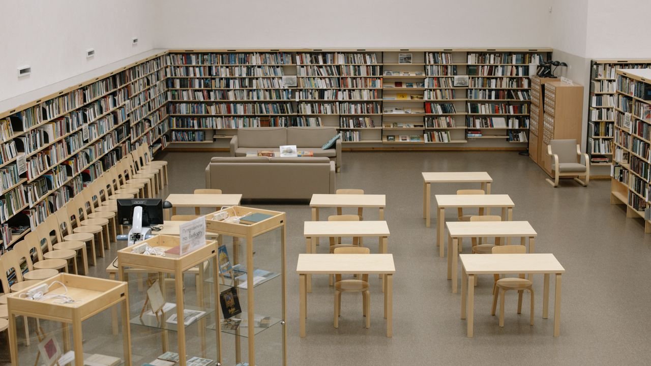 A serene library with bookshelves and wooden furniture, ideal for reading and study.