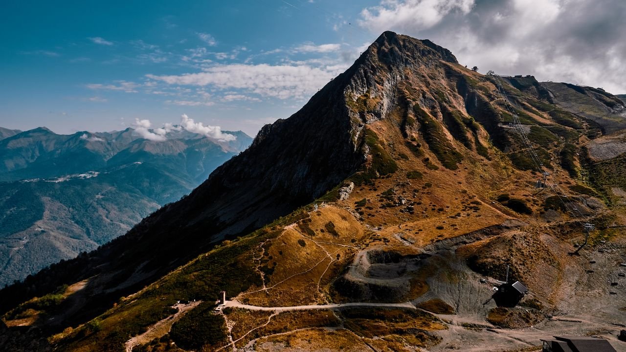 A stunning view of a mountain peak under a blue sky in Sochi, Russia, showcasing natural beauty.