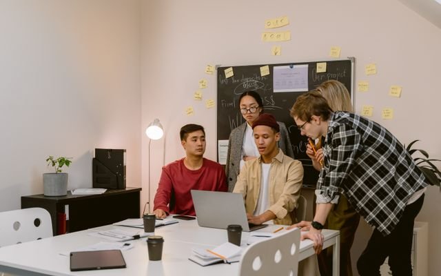 Group of young professionals brainstorming ideas in a collaborative office environment.