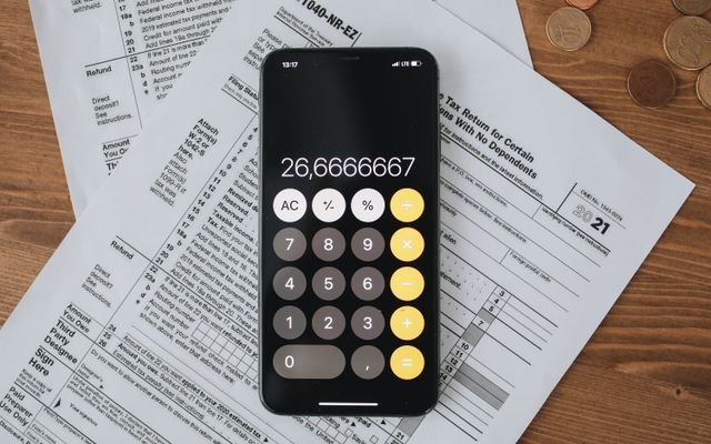 Mobile calculator app on tax documents, highlighting financial calculations and tax preparation.
