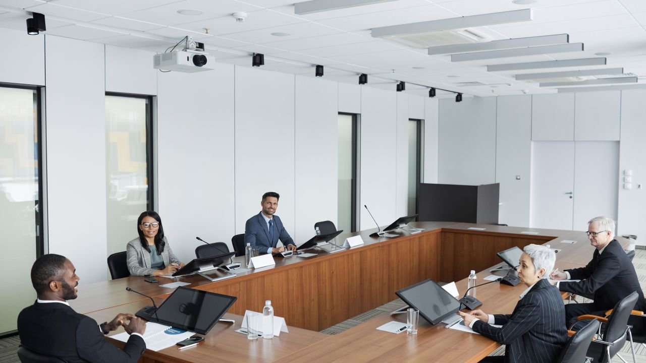 A multicultural group of professionals engaged in a business meeting in a modern conference room.