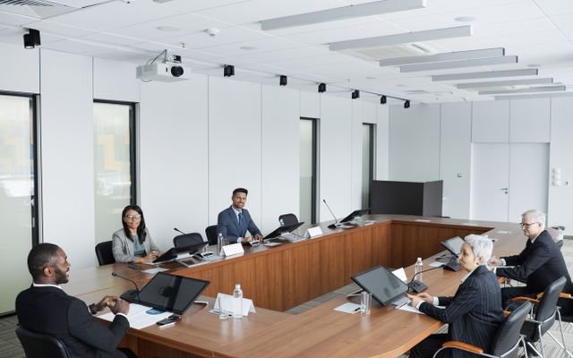 A multicultural group of professionals engaged in a business meeting in a modern conference room.