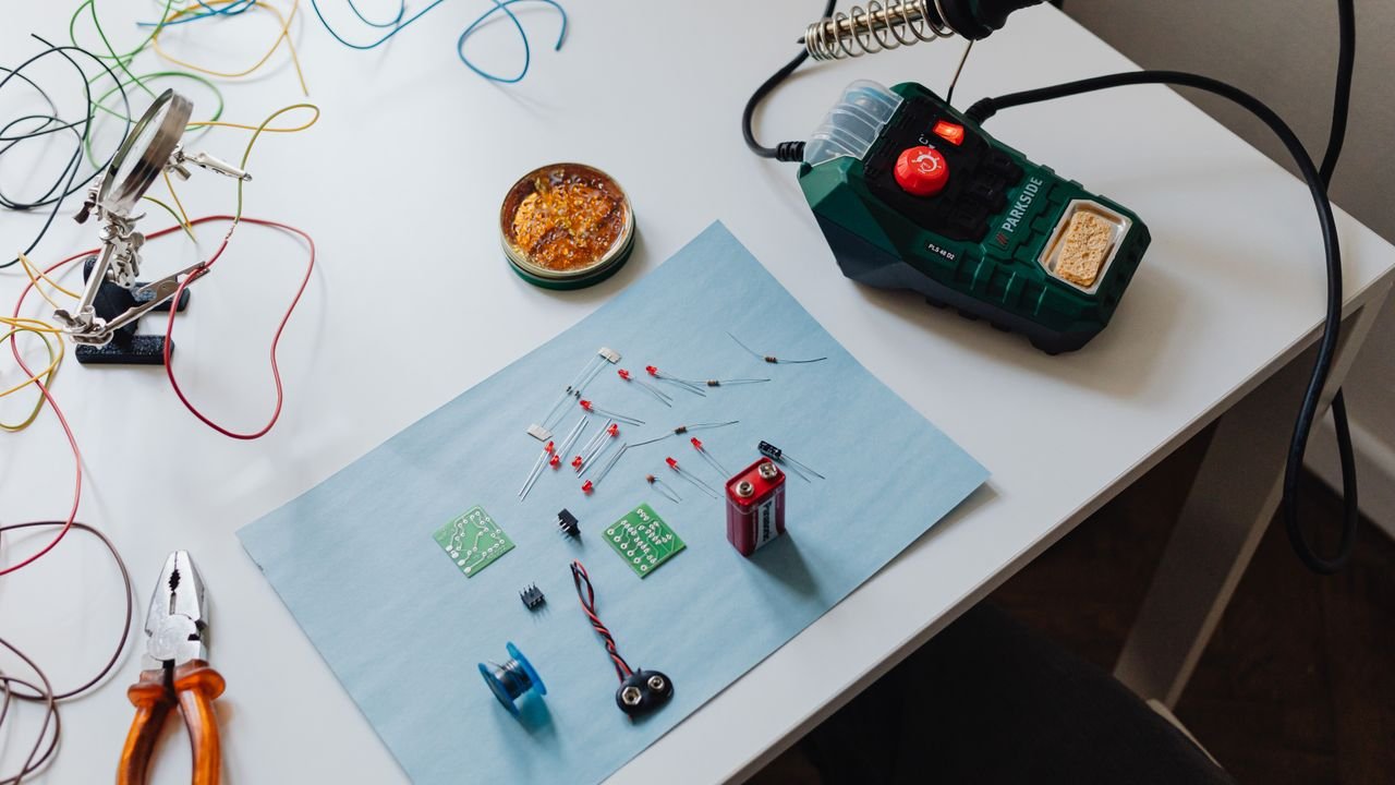 A workspace with a soldering station, tools, and electronic components ready for repair.