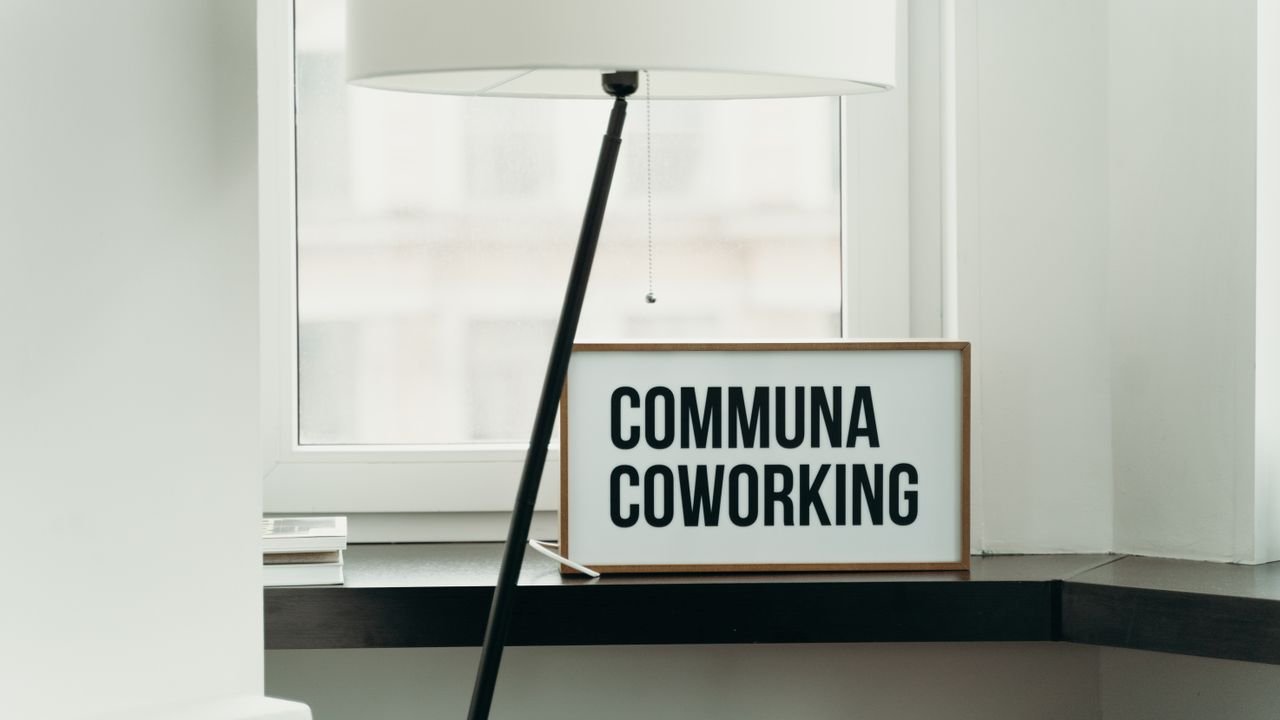 Simple and elegant coworking space decor with soft lamp lighting and window view.